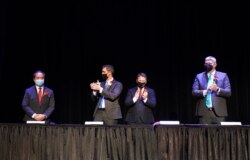 In this photo provided by Peg Shanahan, new Mayor Sokhary Chau, left, is applauded by councillors John Drinkwater, second from left, vice chair Erik Gitschier and Wayne Jenness during the Lowell City Council swearing-in ceremony, Monday, Jan. 3, 2022, in Lowell, Mass.