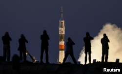 Photographers take pictures as the Soyuz MS-05 spacecraft carrying the crew of Paolo Nespoli of Italy, Sergey Ryazanskiy of Russia and Randy Bresnik of the U.S. blasts off to the International Space Station (ISS) from the launch pad at the Baikonur Cosmodrome, Kazakhstan, July 28, 2017.