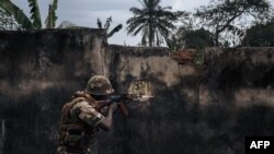 FILE - A soldier of the Central African Army mimics his posture during a Jan. 3, 2021, rebel assault in Bangassou, on Feb. 3, 2021. The country is plagued by fighting between rebels and the army.