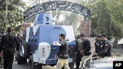 Policemen escort an Armored Personal Carrier (APC) transporting U.S national Raymond Davis as he arrives to appear before a court in Lahore, Pakistan, February 11, 2011