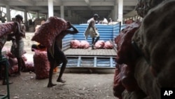 Indian laborers load bags of onions onto a truck in Hyderabad, India ( 2010 file photo)