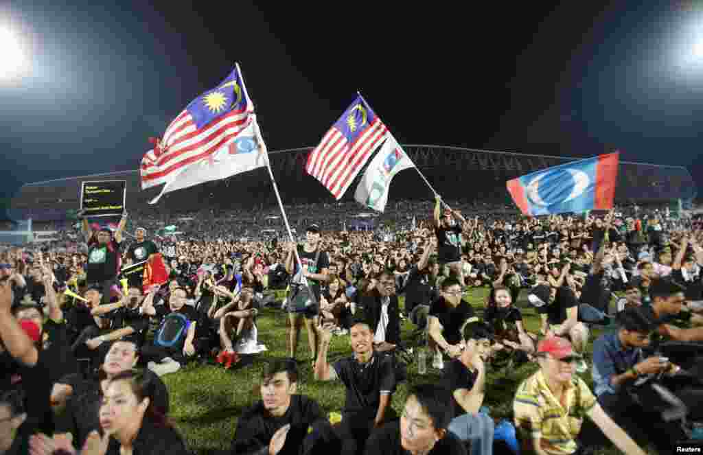 Opposition supporters wave flags as they attend a rally to protest Sunday&#39;s election results at a stadium in Kelana Jaya, Malaysia, May 8, 2013. 