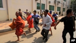 Cambodian Buddhist monks run together with supporters of Cambodian National Rescue Party from a rally site of the Democracy Square in Phnom Penh, file photo. 