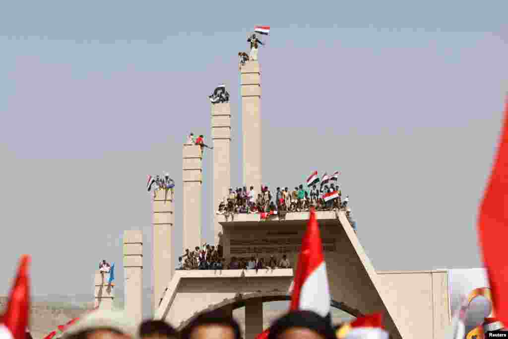 People carry Yemen&#39;s national flag during a ceremony marking the Reunification Day in Sana&#39;a.
