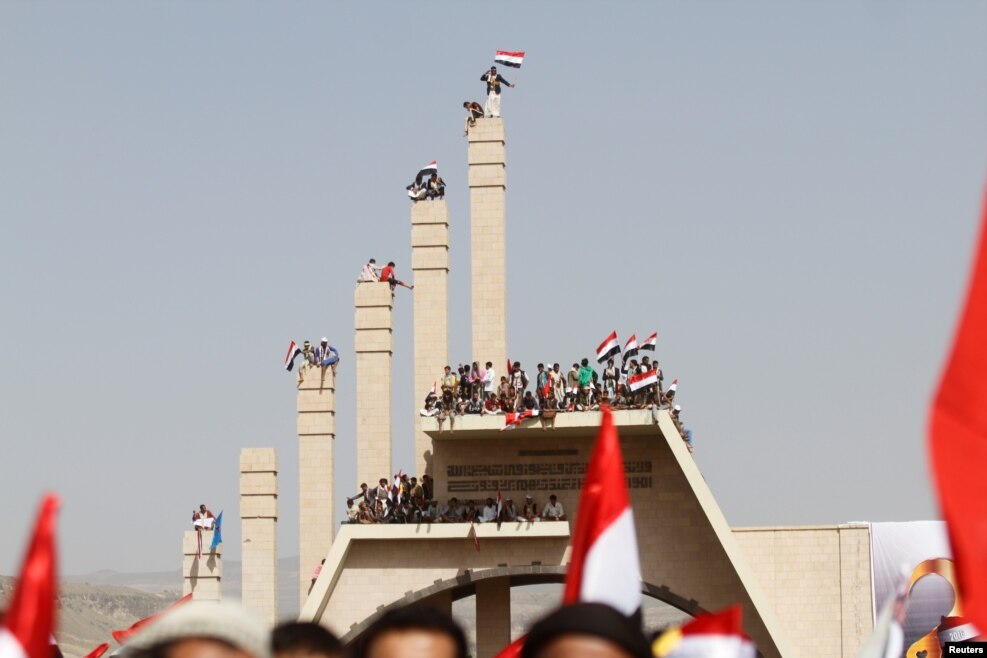 People carry Yemen's national flag during a ceremony marking the Reunification Day in Sana'a.