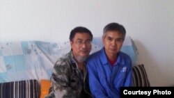 在家被監視居住的失業教師陳平福（左）與成功探望他的維權人士 (博訊圖片)