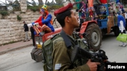 An Israeli soldier secures a parade marking the Jewish holiday of Purim in the West Bank city of Hebron, March 12, 2017.