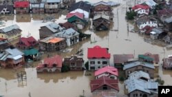 Dân trong vùng bị lụt ở Srinagar, Ấn Độ, chèo xuồng giữa những tòa nhà ngập nước, 9/9/14
