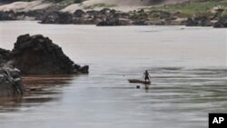 A fisherman works near the site of the proposed Xayaburi Dam in Paksey, northern Laos, file photo. 