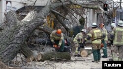 Firefighters remove parts of a tree from a street at Wedding district as Storm Niklas strikes in Berlin, Germany, March 31, 2015.