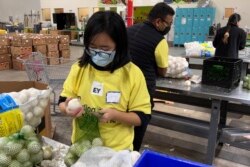 Para sukarelawan mengemas bawang di gudang Bank Makanan Komunitas Alameda County di Oakland, California, 5 November 2021.