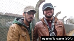 Anh Ahmad Hamdan và anh Abdulnasir Tahir đứng bên ngoài trại tị nạn ở gần Giessen, Đức.