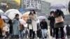 Warga berjalan di penyeberangan Shibuya saat hujan salju turun pada Kamis, 6 Januari 2022, di Tokyo, Jepang. (Foto: AP)