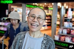 Liu Xia, the widow of Chinese Nobel dissident Liu Xiaobo, reacts as she arrives at the Helsinki International Airport in Vantaa, Finland, Tuesday, July 10, 2018.