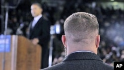 A Secret Service agent stands near then-presidential candidate Barack Obama [background] at a rally in Norfolk, Virginia, October 2008 (file photo)
