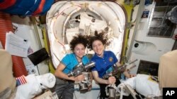 En esta foto divulgada por la NASA el jueves, 18 de octubre, de 2019, se ven las astronautas Jessica Meir (izquierda) y Christina Koch, posando para una foto en la estación espacial internacional, ante de iniciar la histórica caminata espacial de solo mujeres.