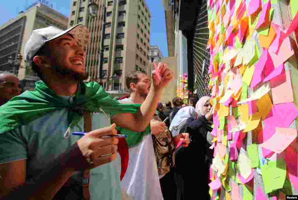 People write slogans and messages on sticky notes during a protest demanding immediate political change in Algiers, Algeria after ailing President Abdelaziz Bouteflika announced he is delaying the April 18 election and won&#39;t seek another term.