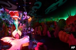 FILE - Tourists experience the Under the Sea — Journey of the Little Mermaid movie-inspired ride at the Walt Disney World Resort's Magic Kingdom theme park in Lake Buena Vista, Fla., Dec. 6, 2012.