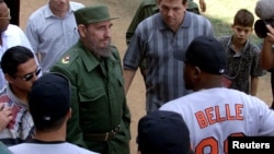 A March 28, 1999 file photo shows then-Cuban President Fidel Castro talking with Baltimore Orioles slugger Albert Belle (88) prior to the exhibition game between the Orioles and a Cuban National Team
