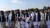 Juru bicara Taliban Zabihullah Mujahid (tengah, membawa selendang) didampingi oleh para pejabat untuk membrikan keterangan kepada media di bandara Kabul, 31 Agustus 2021. (WAKIL KOHSAR / AFP)