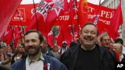 Opposition activists Gennady Gudkov, right, and Ilya Ponomarev, a lawmaker, left, march with opposition supporters heading to a protest rally in Moscow, September 15, 2012.