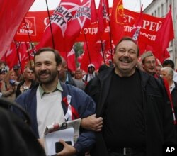 FILE - Opposition activists Gennady Gudkov, center, and Ilya Ponomarev, a lawmaker, left, march with opposition supporters heading to a protest rally in Moscow, Sept. 15, 2012.