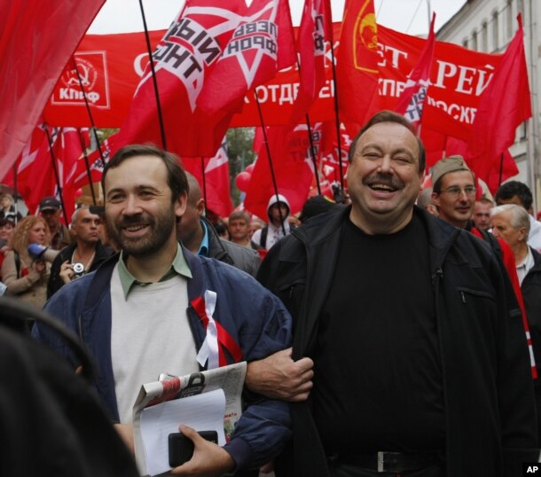 FILE - Opposition activists Gennady Gudkov, center, and Ilya Ponomarev, a lawmaker, left, march with opposition supporters heading to a protest rally in Moscow, Sept. 15, 2012.