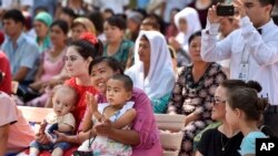 Uzbeks watch a performance at a park in downtown Tashkent, Uzbekistan, during Independence Day festivities, Sept. 1, 2016.