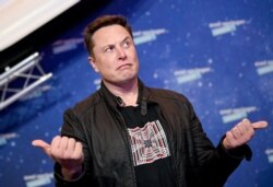 Pemilik SpaceX dan CEO Tesla Elon Musk (kanan) memberi isyarat saat ia tiba di karpet merah untuk upacara Axel Springer Awards, di Berlin, pada 1 Desember 2020. (Foto: AFP/Britta Pedersen)