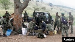 Les soldats congolais des Forces armées de la République démocratique du Congo (FARDC) font une pause pendant leur offensive contre les rebelles des Forces démocratiques pour la libération du Rwanda (FDLR) dans le village de Kirumba, dans le district de Rutshuru, dans l'est de la RDC, 27 février 2015.