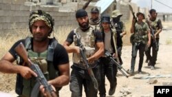 Iraqi Shi'ite fighters from the Popular Mobilization units deploy in the city of Baiji, north of Tikrit, as they fight alongside Iraqi forces against the Islamic State jihadist group to try to retake the strategic town for a second time, June 9, 2015. 