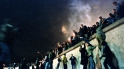 1989 年 11 月 9 日东德边境开放后，人们在勃兰登堡门攀登柏林墙。(路透社/Herbert Knosowski)