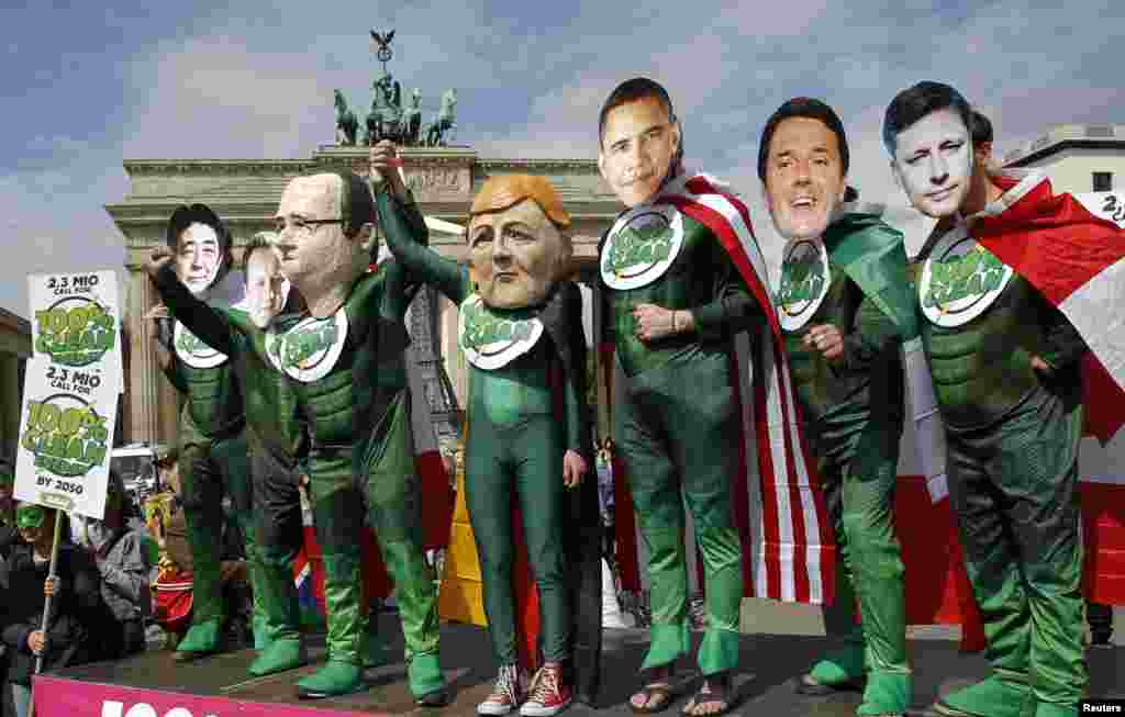 AVAAZ environmental activists wear masks depicting leaders of the member countries of the G7, (L-R) Japanese Prime Minister Shinzo Abe, British Prime Minister David Cameron, French President Francois Hollande, German Chancellor Angela Merkel, U.S. President Barack Obama, Italian Prime Minister Matteo Renzi and Canadian Prime Minister Stephen Harper during a rally in front of the Brandenburg Gate near the venue where the Petersberg Climate Dialogue takes place in Berlin, Germany.