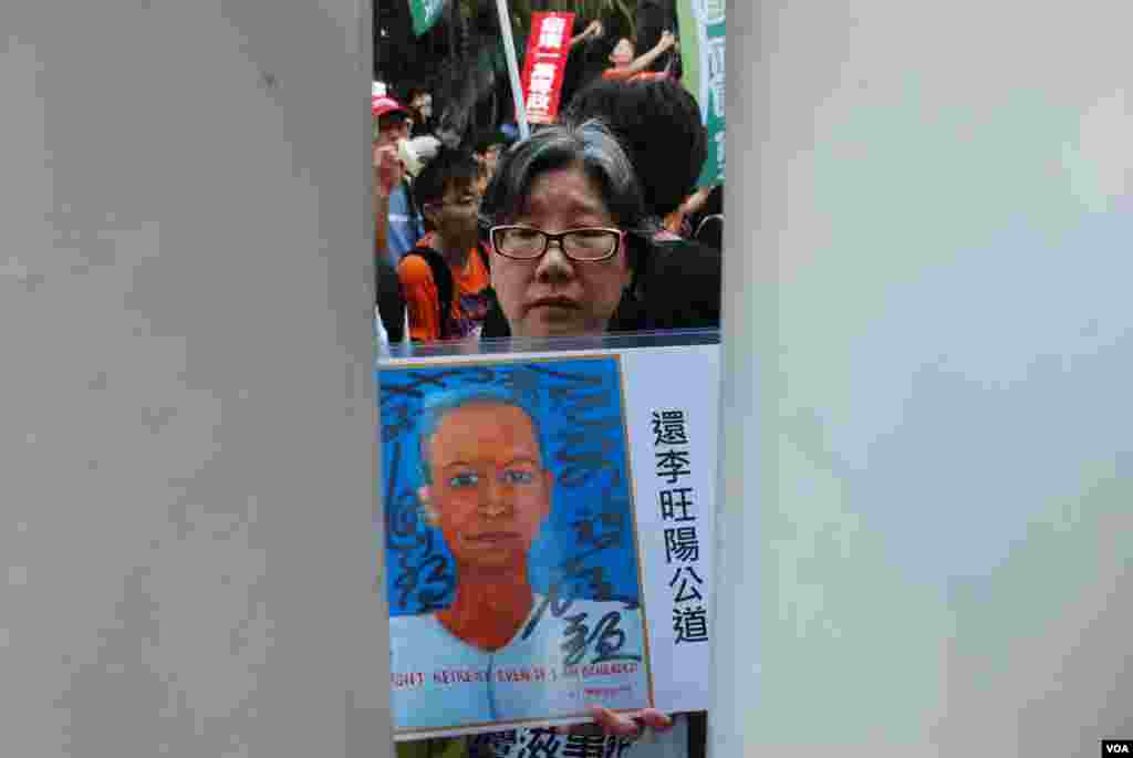 有示威者在狹窄的水馬間隙展示為李旺陽申冤的標語