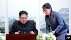 지난달 파주 판문점 평화의 집에서 열린 남북정상회담 직전, 김정은 북한 국무위원장이 방명록 작성하려고 하자 김여정 당 중앙위원회 제1부부장(오른쪽)이 보조를 하고 있다. 