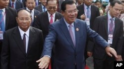 Cambodia's Prime Minister and President of the People's Party, Hun Sen, center, arrives at an event marking the 38th anniversary of the 1979 downfall of the Khmer Rouge regime in Phnom Penh, Cambodia, Saturday, Jan. 7, 2017. (AP Photo/Heng Sinith)