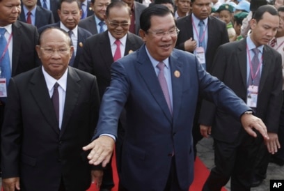 FILE-Cambodia's Prime Minister and President of the People's Party, Hun Sen, center, arrives at an event marking the 38th anniversary of the 1979 downfall of the Khmer Rouge regime in Phnom Penh, Cambodia, Saturday, Jan. 7, 2017. (AP Photo/Heng Sinith)