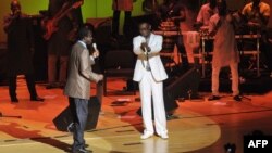 Senegalese singer and Culture Minister Youssou Ndour (C) and Senegalese singer Thione Seck (L) perform at a relief concert for flood victims at Dakar's Grand Theater on September 8, 2012.