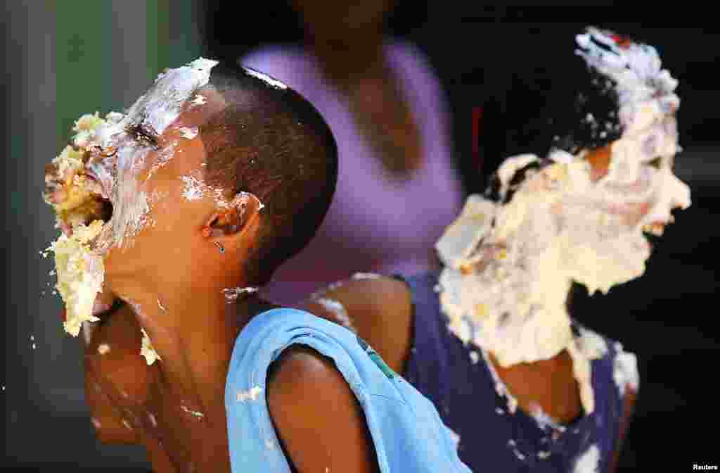Reaksi anak-anak yang wajahnya dilumuri krim dari kue sepanjang 450 meter yang disiapkan sebagai bagian dari perayaan ulang tahun ke-450 kota Rio de Janeiro, Brazil, 1 Maret 2015.