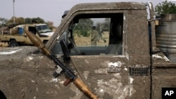 A rocket propelled launcher hangs on the mirror of a pickup truck in the Nigerian city of Damasak March 18, 2015.