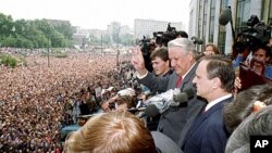 Gennady Burbulis, right, stands next to Russian Republic President Boris Yeltsin, second right, making a V-sign to thousands of Muscovites at a rally in front of the Russian federation building to celebrate the failed military coup in Moscow, August 22, 