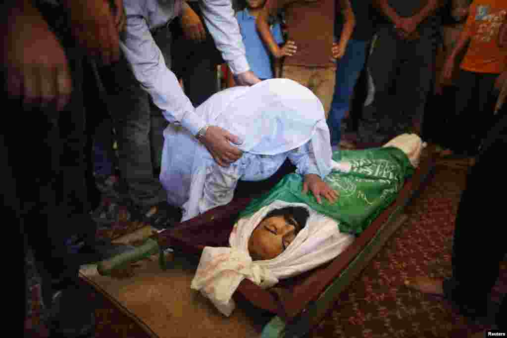 The mother of a Palestinian Hamas militant killed in an Israeli air strike mourns as she looks at his body during his funeral in Jabaliya in the northern Gaza Strip, Aug. 21, 2014.