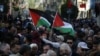 Des Palestiniens agitent des drapeaux nationaux, marchAnt dans les rues de la ville occupée de Ramallah, en Cisjordanie, appelant à la cessation des divisions entre le Fatah et le Hamas, à l'unification de la Cisjordanie et de la bande de Gaza, le 12 janvier 2019 (AFP/A. MOMANI)