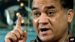 FILE - Ilham Tohti, a champion of China's Uighur minority who was jailed last year and whose plight is being highlighted by the "Press Uncuffed: Free the Press" campaign, gestures during an interview in his Beijing home, Feb. 4, 2013.