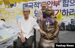 지난 2016년 8월 서울 종로구 중학동 주한 일본대사관 앞에서 '세계 일본군 위안부 기림일'을 맞아 열린 '나비 문화제'에 참석한 김복동 할머니가 소녀상 옆 빈 의자에 앉아있다. 오른쪽은 길원옥 할머니.
