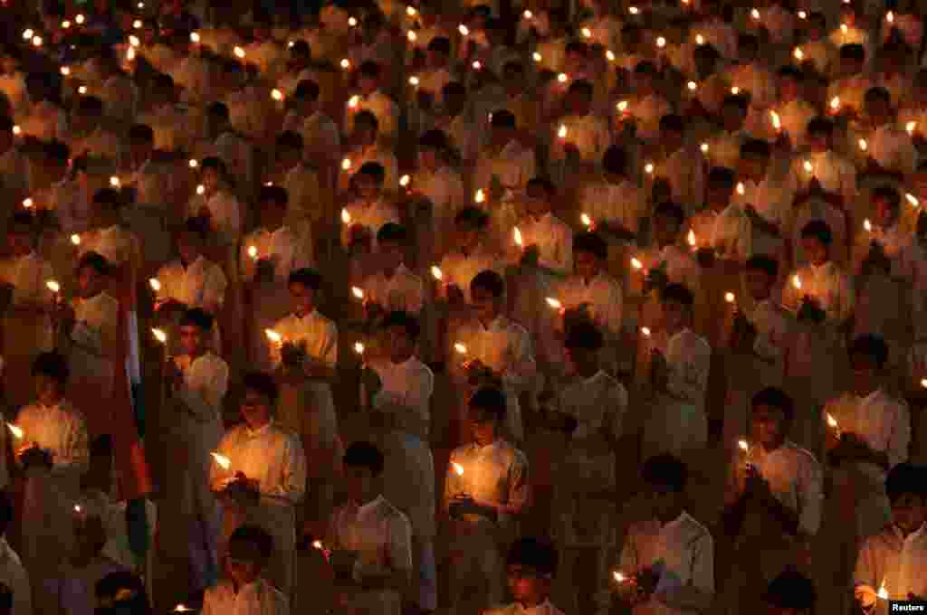 Students hold candles during a vigil to pay tribute to Central Reserve Police Force (CRPF) personnel who were killed after a suicide bomber rammed a car into a bus carrying them in south Kashmir on Thursday, inside a temple in Ahmedabad, India.