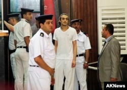 FILE - Egyptian photojournalist Mahmoud Abu Zied, known by his nickname Shawkan, center, appears before a judge for the first time after spending more than 600 days in prison in Cairo, May 14, 2015.