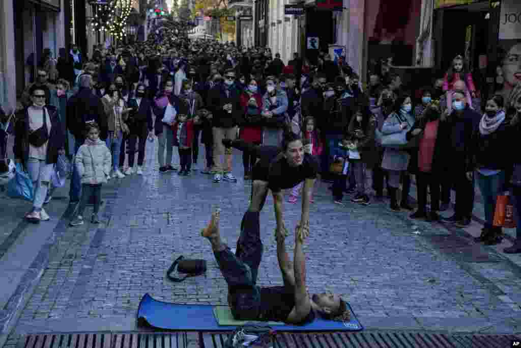 Street artists perform on Ermou Street, Athens&#39; main shopping area.