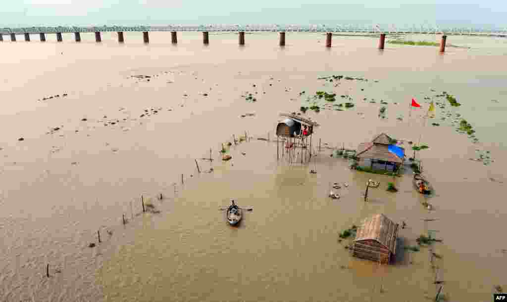 Những căn chòi trơ trọi giữa biển nước khi mực nước sông Hằng dâng cao tràn bờ ở Allahabad. Mưa lớn ở một số khu vực miền bắc Ấn Độ khiến sông dâng nước cao đến mức nguy hiểm. 