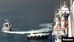 Para migran dipindahkan dari kapal milik LSM Aita Maria ke kapal Italia, Rubattino di lepas pantai Palermo, Italia, Minggu, 19 April 2020. Mereka dipindahkan untuk dikarantina karena wabah virus corona (Covid-19).